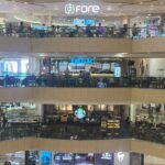 Tiga jaringan kedai kopi - Fore Coffee, Excelso, dan Starbucks - tampak berdiri secara vertikal di atrium Tunjungan Plaza, Surabaya, Minggu malam (26/7/2026)