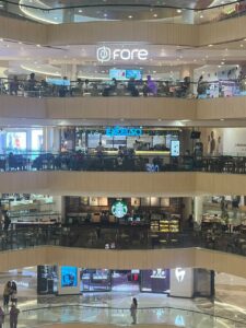 Tiga jaringan kedai kopi - Fore Coffee, Excelso, dan Starbucks - tampak berdiri secara vertikal di atrium Tunjungan Plaza, Surabaya, Minggu malam (26/7/2026)